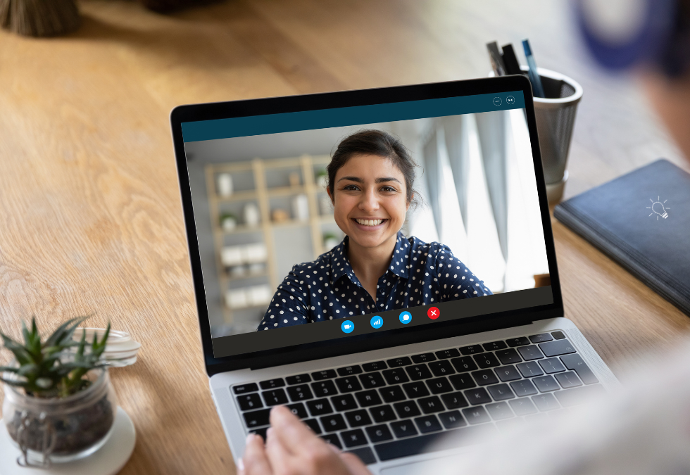 A stay interview to improve retention being conducted online. The employee smiles as she answers the questions of the interviewer.